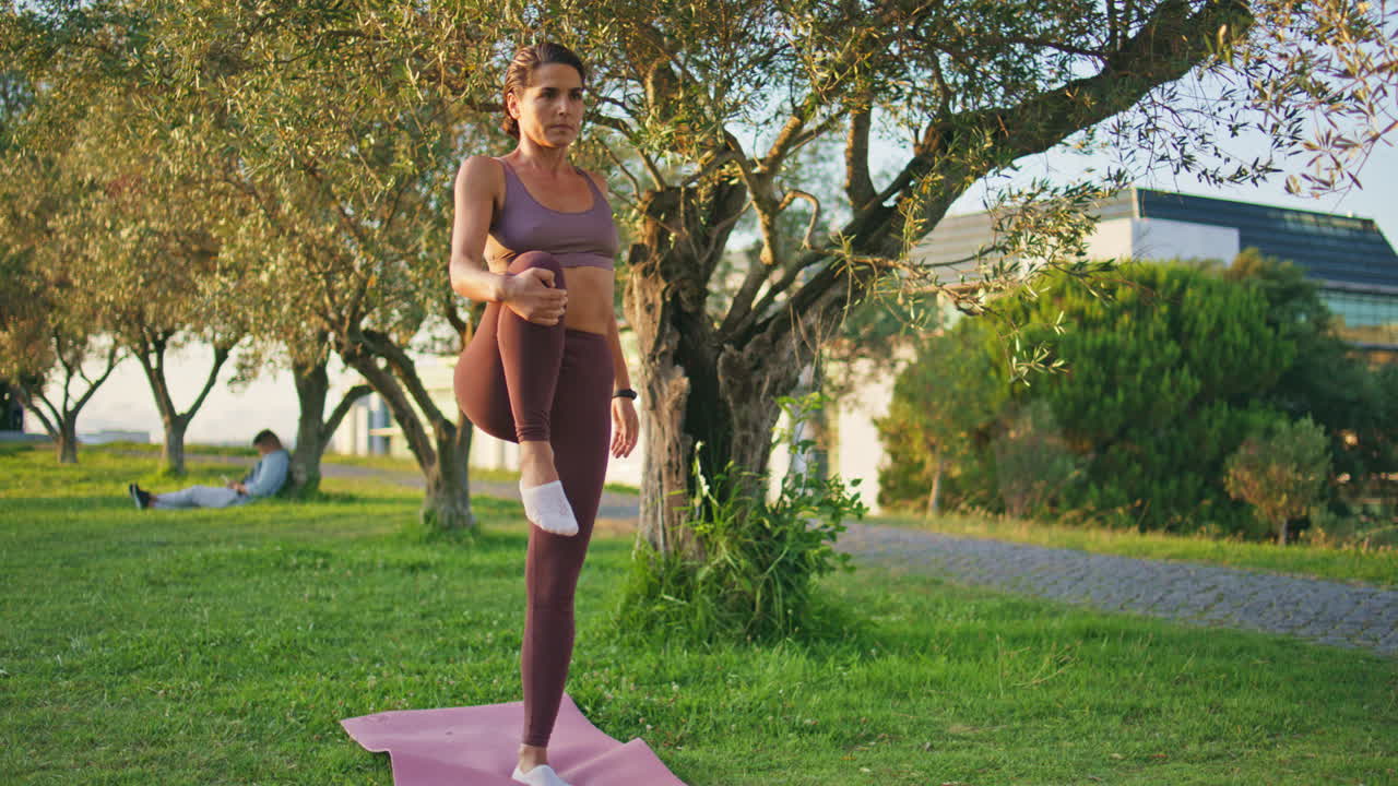 modelo de yoga practicando asana en el parque soleado zoom en. mujer realizando estiramiento