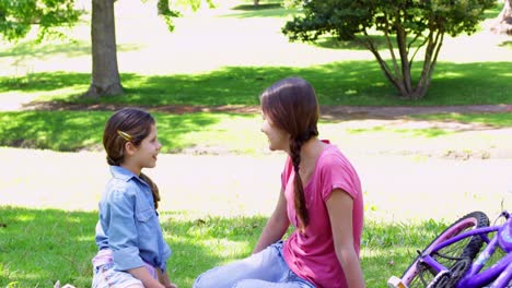 Happy-mother-and-daughter-taking-a-break-on-their-bike-ride