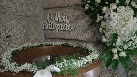 floral baptism setup with decorated christening font and white blooms