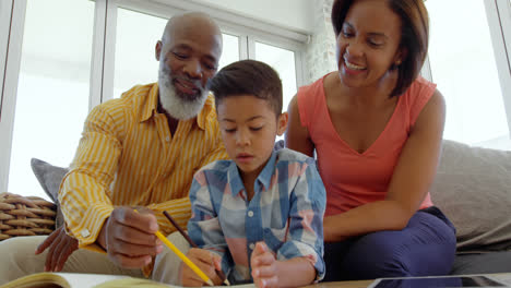 Vorderansicht-Von-Schwarzen-Eltern,-Die-Ihrem-Sohn-Bei-Den-Hausaufgaben-In-Einem-Komfortablen-Zuhause-Helfen,-4k