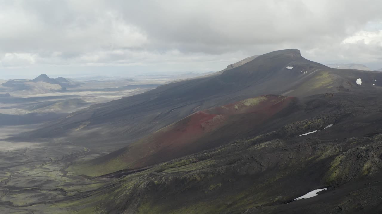 vista aérea del cráter cerca del volcán hekla en las tierras altas de islandia durante el día nublado - tiro que se acerca
