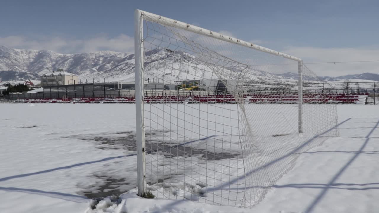 Football goal in winter on a football field covered in snow. Season. Weather.