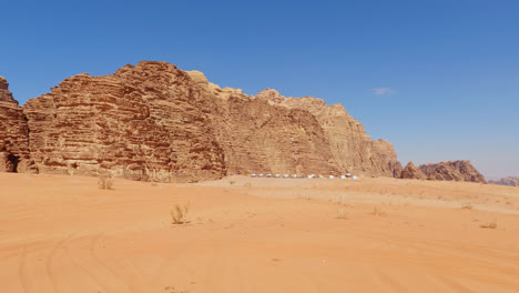 altos acantilados épicos de piedra arenisca se elevan contra el suelo arenoso del desierto