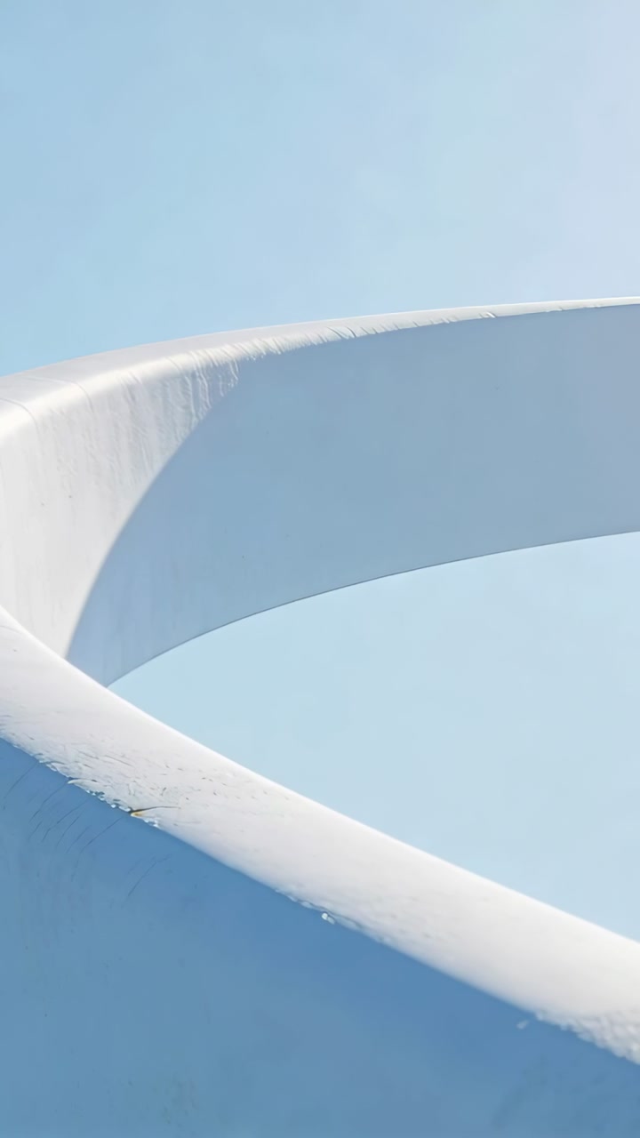 Slow Motion Rotation of a White Abstract Sculpture Against Blue Sky
