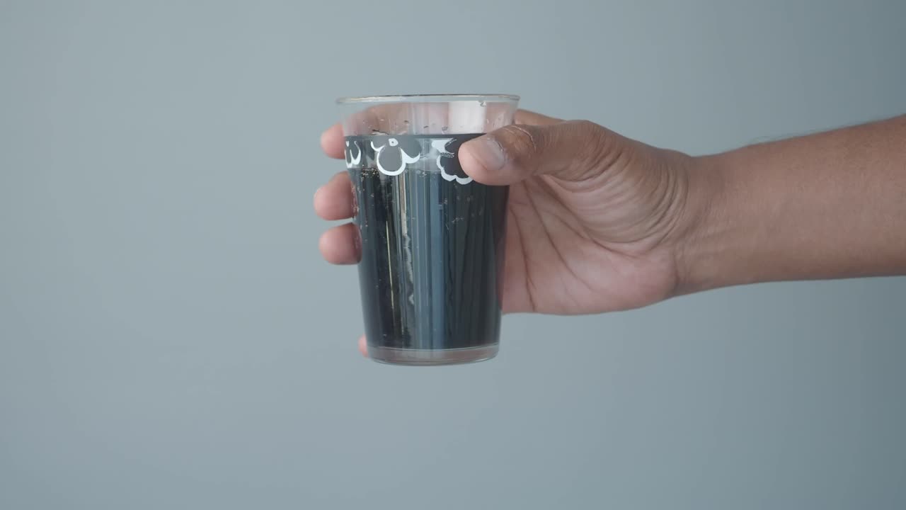 Una mano che regge un bicchiere di soda