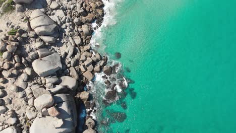 tranquil aerial tropical paradise with turquoise water waves crashing on rocks