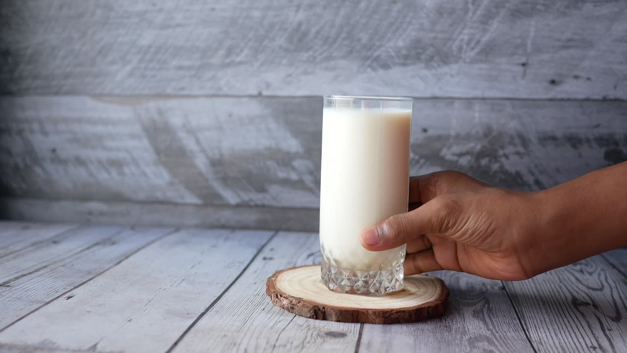 hombre con un vaso de leche en la mano temprano en la mañana ,