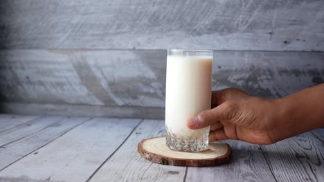 man hand holding glass of milk at early morning ,