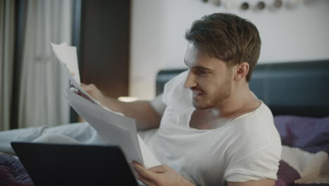 Happy-man-reading-business-papers-at-home