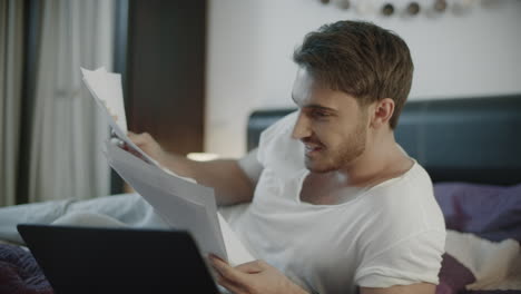 happy man reading business papers at home