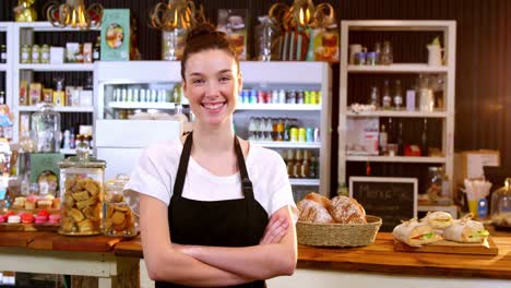 portrait of smiling waitress standing with arms crossed