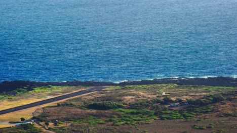 high angle establishing shot of kalaupapa airport and small plane landing on the island of molokai hawaii 1