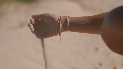 mujer dejando caer arena