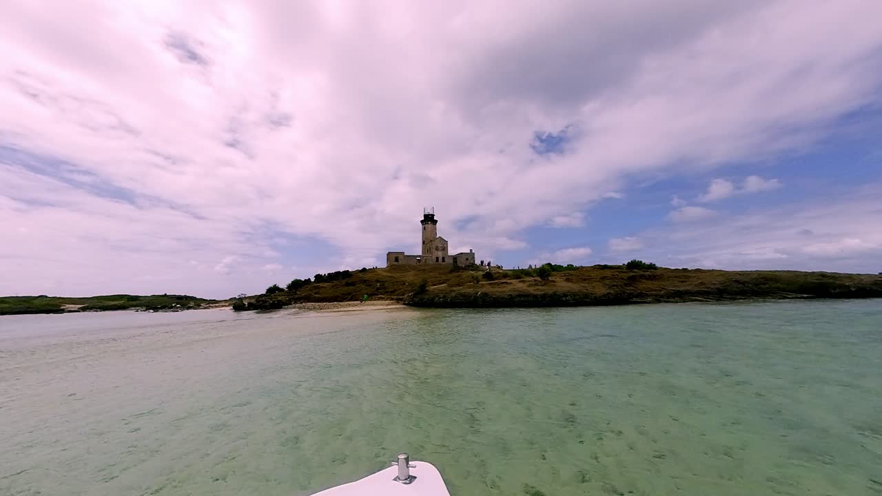 A stunning panoramic view of a boat arriving at the picturesque lighthouse island in Mahebourg, Mauritius, surrounded by the Indian Ocean.