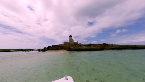 a stunning panoramic view of a boat arriving at the picturesque lighthouse island in mahebourg, mauritius, surrounded by the indian ocean.