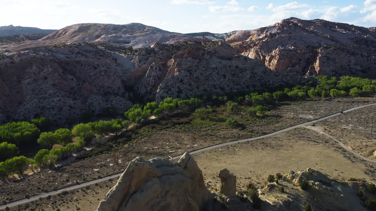 un automóvil que conduce por una carretera que cruza un valle del cañón, inclina