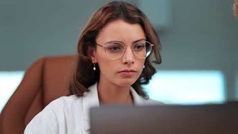 Young-Businesswoman-Listens-and-Nods-in-Agreement-at-Modern-Office,-Notebook-in-Focu