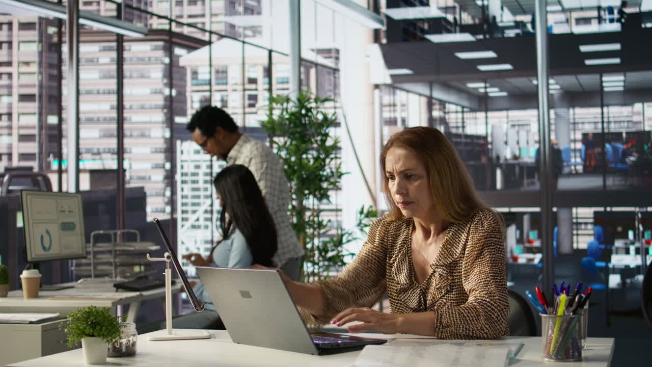 Kontormiljø med folk, der arbejder på bærbare computere