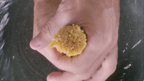 the hand of a chef dropping raw uncooked spaghetti into a boiling pot, with the water stream creating circles