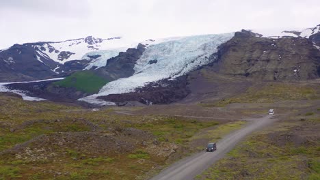 Antenne-über-Einem-Schwarzen-Wohnmobil,-Das-Zu-Einem-Abgelegenen-Gletscher-In-Den-Bergen-Islands-Fährt-2