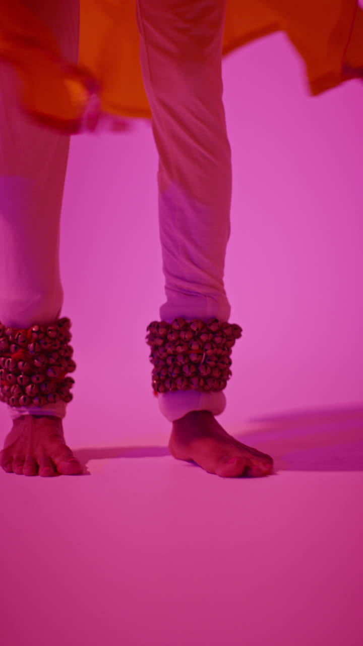 Vertical Video Close Up Of Feet With Bells Of Female Kathak Dancer Performing Dance Wearing Traditional Indian Dress Against Purple Background 3