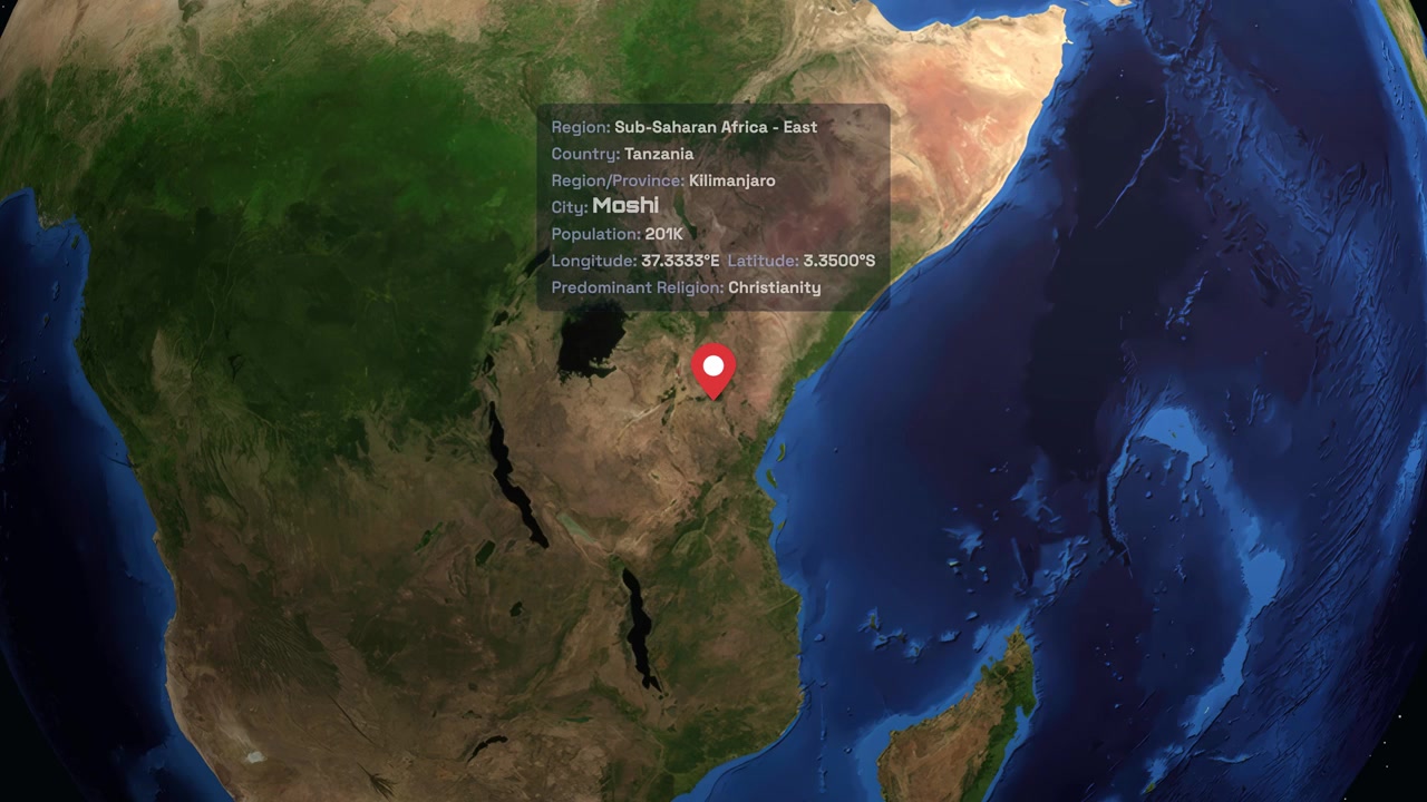 Un globo digitale ruota e zooma sull'Africa orientale, evidenziando Moshi, Tanzania, con dati testuali informativi