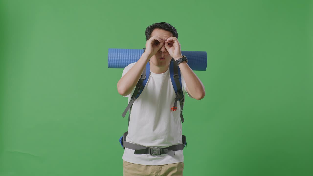 녹색 스크린 앞에 포즈를 취하는 배을 가진 남자