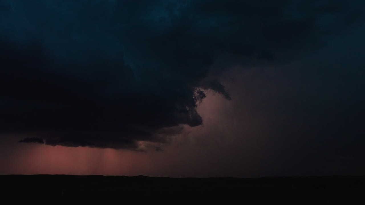 Quiet landscape beneath active lightning storm showing power in atmosphere