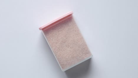 sal del himalaya rosa cruda y seca entera en un recipiente en blanco,