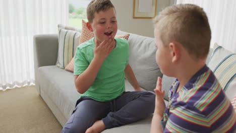 Dos-Hermanos-Caucásicos-Golpeándose-El-Pecho-Sentados-En-El-Sofá-De-Casa