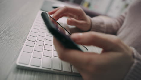 female hands typing on computer keyboard. woman hands texting on mobile phone