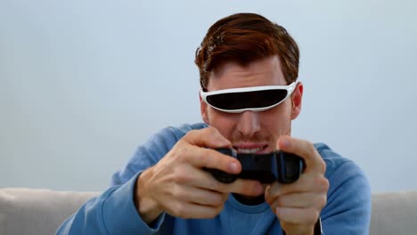 hombre jugando un juego de joystick con auriculares de realidad virtual en el sofá 4k