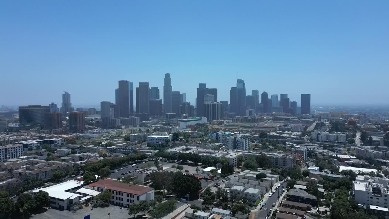 Aerial drone shot flying over Los Angeles houses revealing the city skyline in 4K 60FPS. Calm, cinematic view of urban life and architecture
