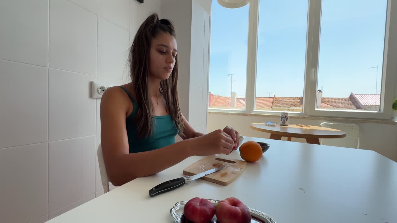Joven cortando fruta fresca en una cocina luminosa