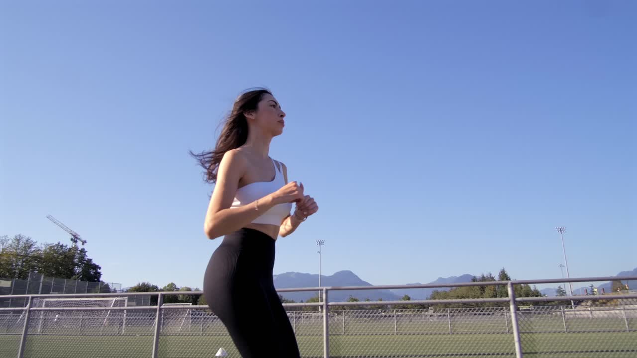 トラックを周回する美しい少女をローアングルで追跡撮影。