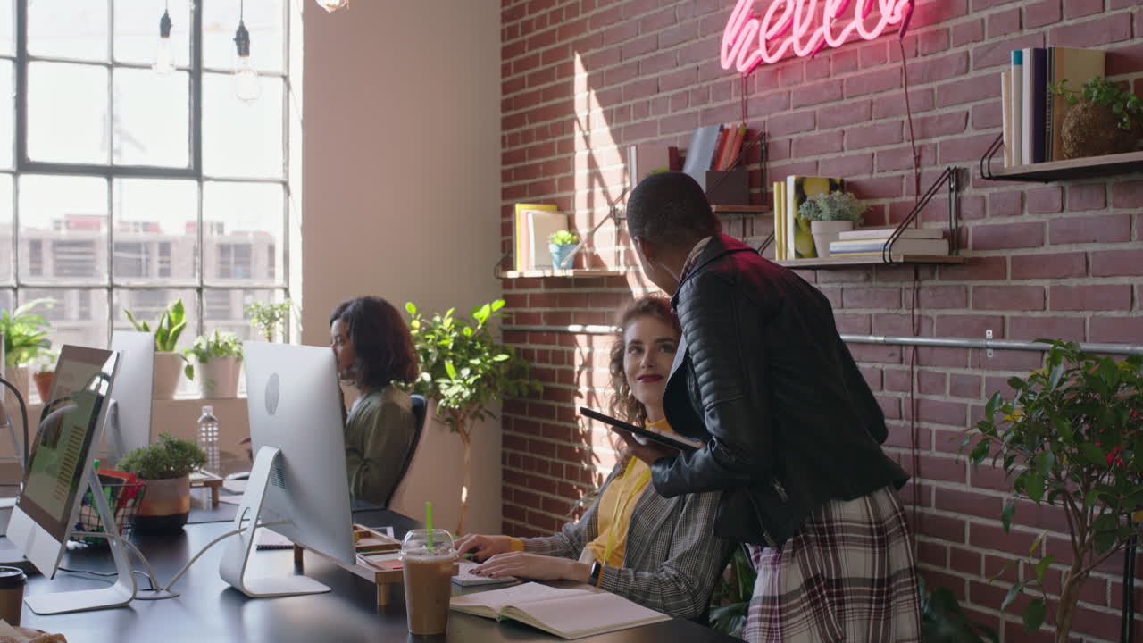 young african american business woman team leader enjoying management career checking colleagues working using tablet computer in diverse office workplace walking confident female manager
