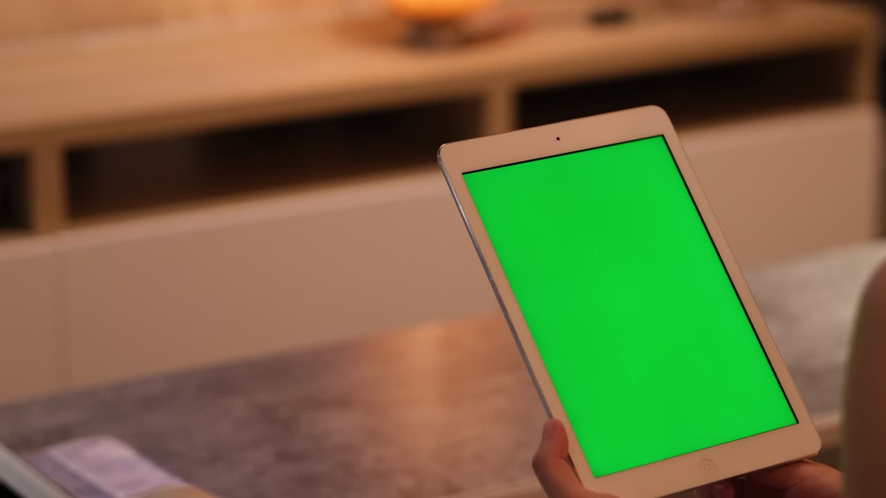 hand touching, tapping and scrolling green screen tablet at home