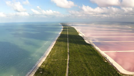 Long-road-on-grassy-isthmus-between-ocean-beach-and-pink-salt-ponds