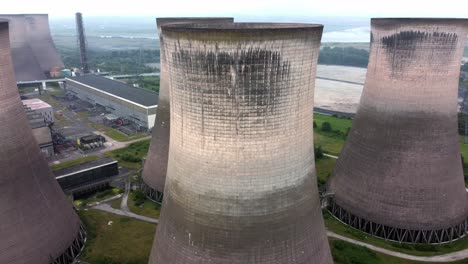 Disused-industrial-energy-power-plant-cooling-smoke-stake-chimneys-aerial-view-pull-away-orbit-right