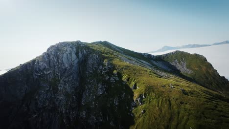 cinematic fpv drone shot stabilized from lofoten revealing the cloud covered landscape of norway from behind the mountain