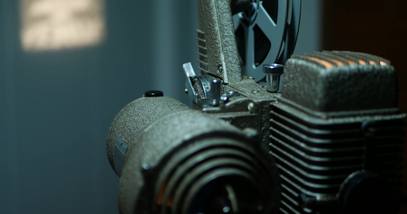 Primo piano di un proiettore vintage da 8mm che proietta su una parete sullo sfondo