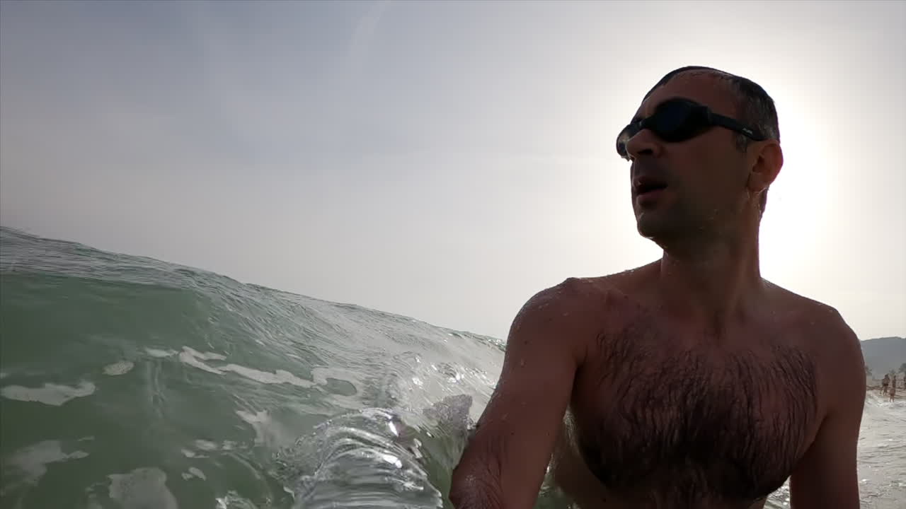 Man wearing swimming googles swimming in the sea