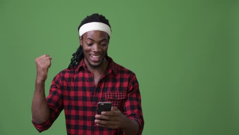 young handsome african man with dreadlocks against green background
