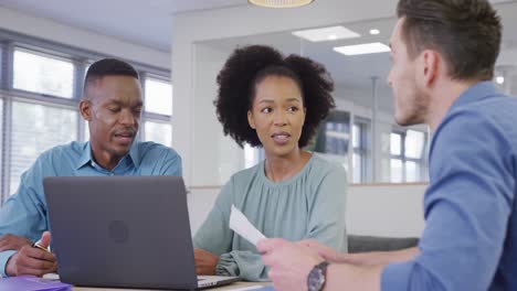 Happy-diverse-business-people-discussing-work-and-using-laptop-at-office,-slow-motion