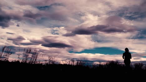 Beautiful-black-silhouette-outline-of-a-female-jogger,-jogging-against-a-dramatic-sky