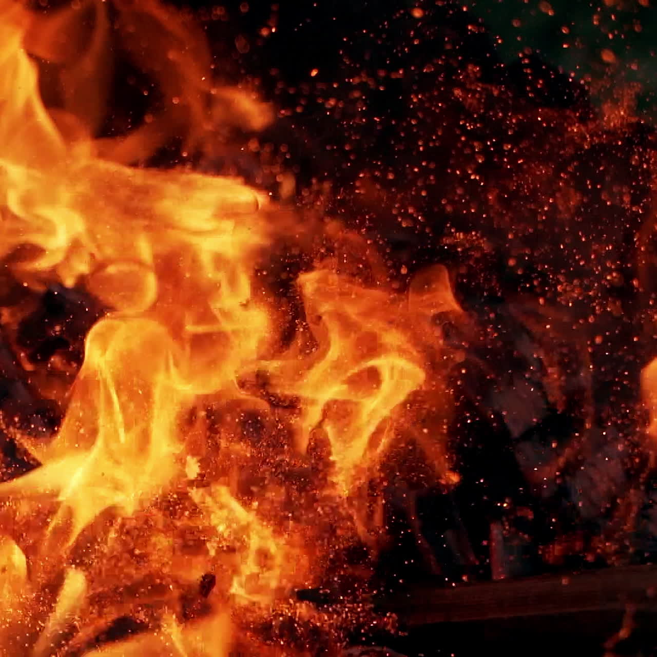 Bonfire. Burning logs in orange flames. Beautiful fire burns brightly. Embers of the fire climb up. Slow motion