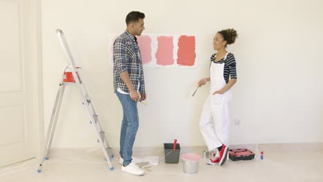 pareja joven tratando de decidir sobre un color de pintura