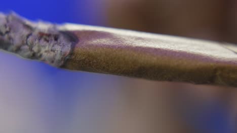 panning shot of a black man holding a burning blunt or marijuana cigarette