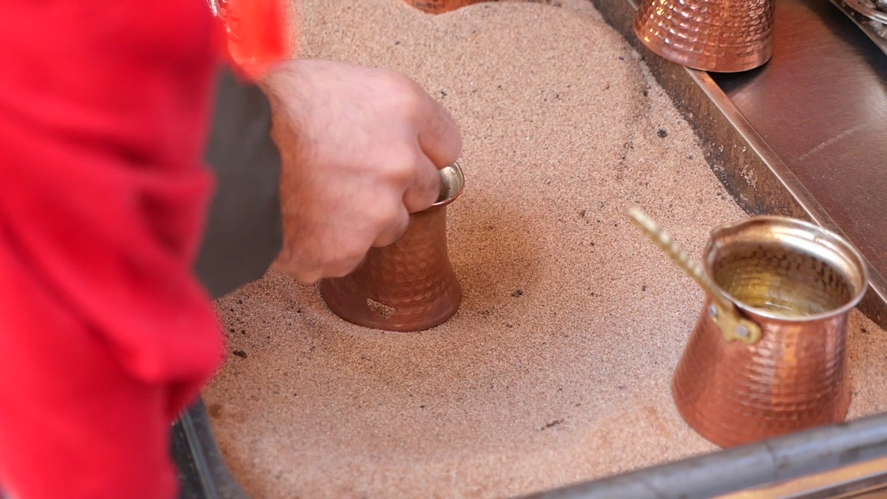 Man Making Traditional Turkish Coffee in Hot Sand