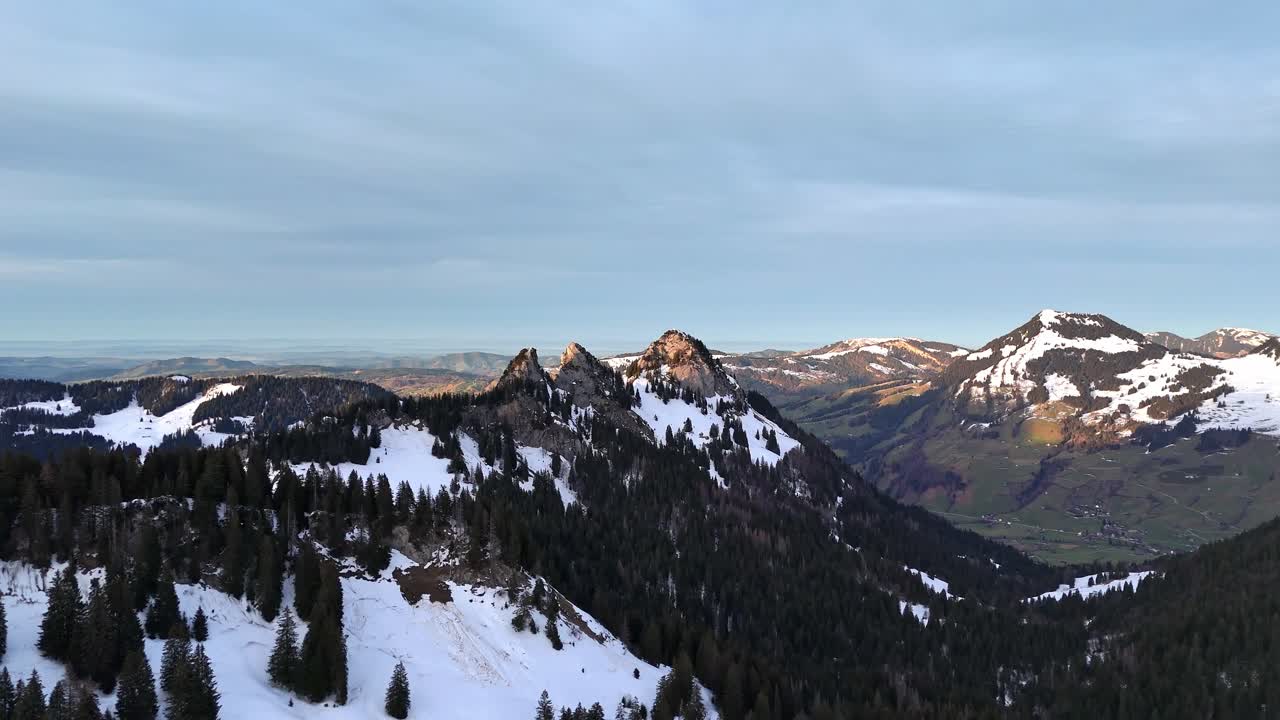 vuelo de avión no tripulado cinematográfico sobre los hermosos alpes suizos en la temporada de invierno y rayos de sol en el pico de las montañas